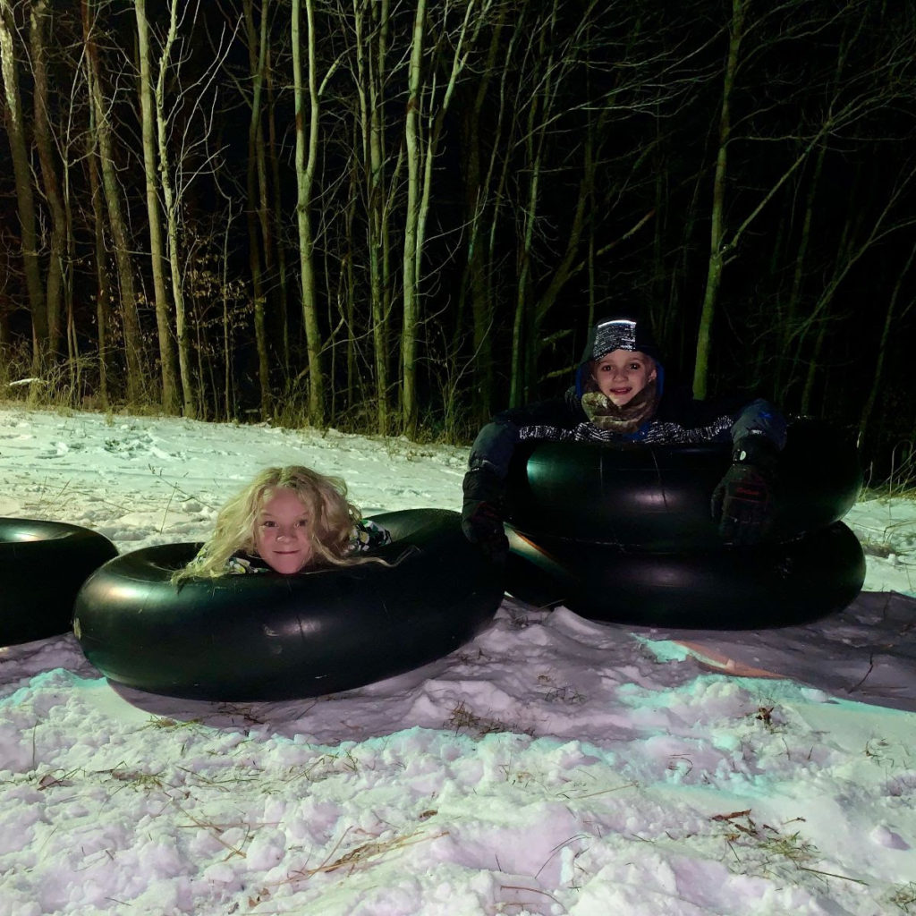 Two girls snow tubing during the night at the Rock Mountain Winter Fun Night.